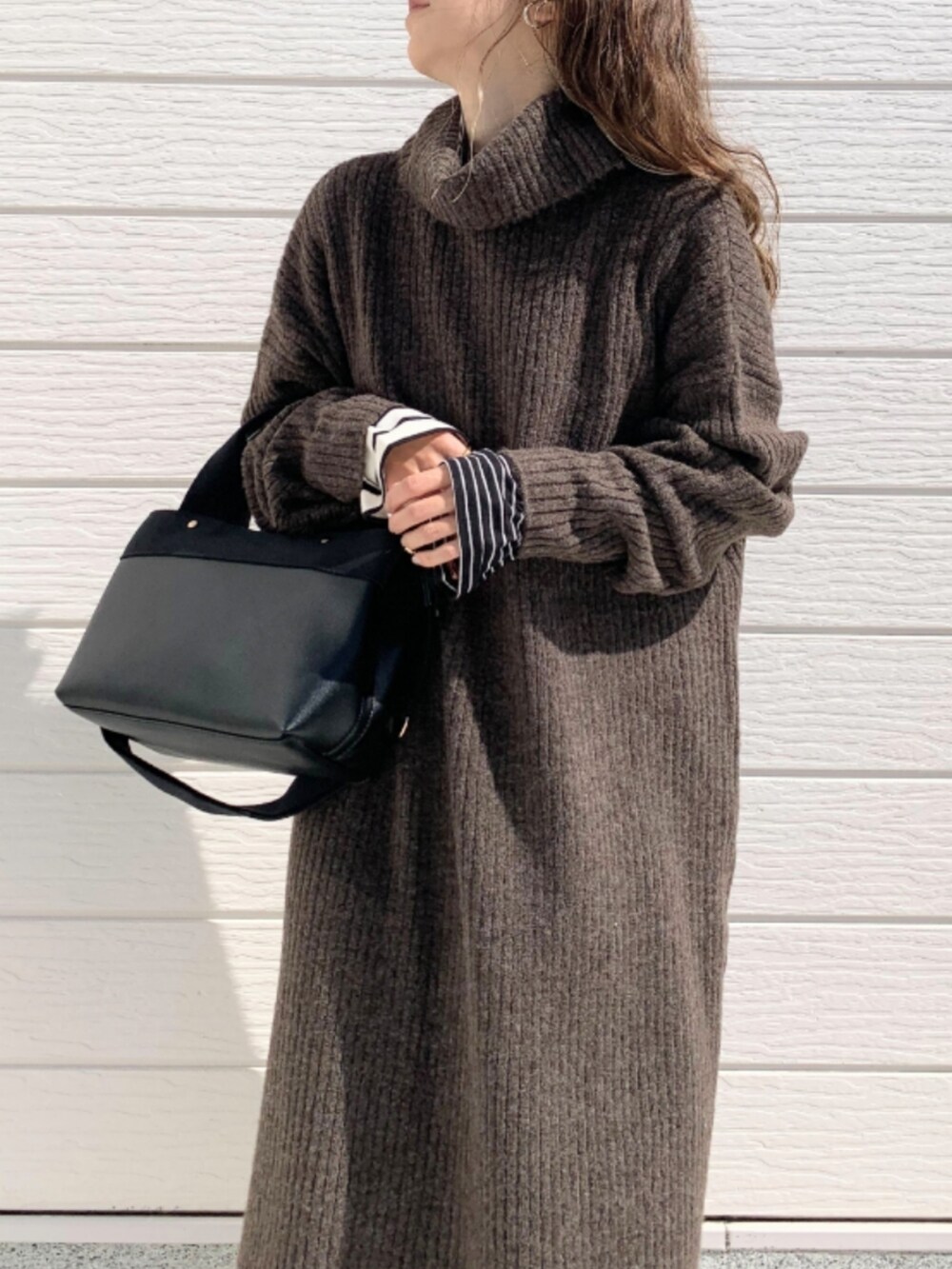 ブラウン系のブーツ、ブラック系のトートバッグ、ホワイト系のTシャツ/カットソーを着用したレディースの秋コーディネートの5枚目の写真
