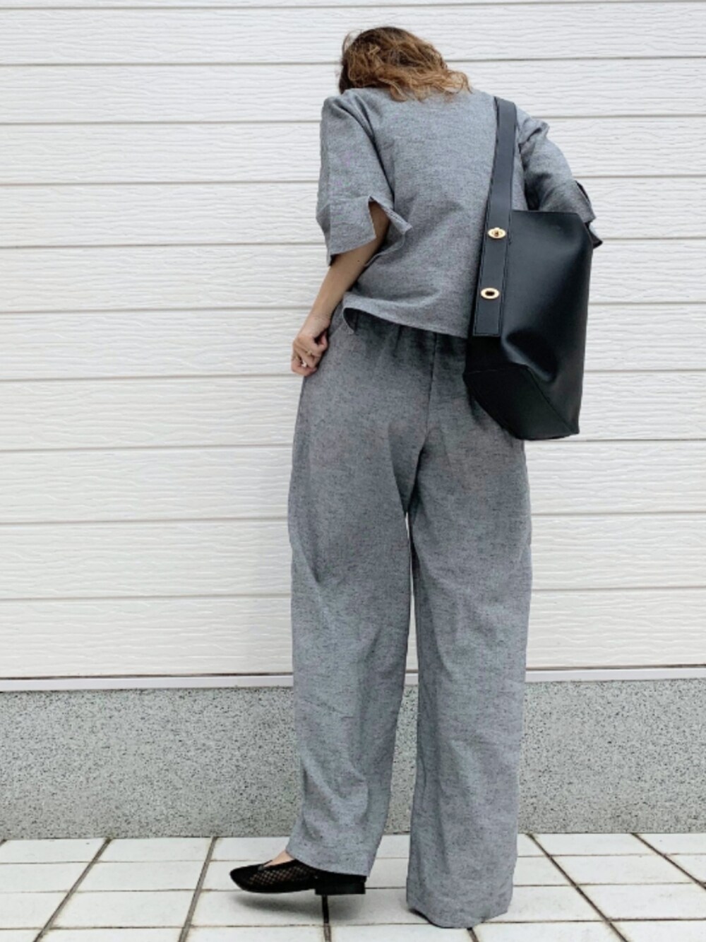 ブラック系のトートバッグ、グレー系のその他パンツ、グレー系のシャツ/ブラウスを着用したレディースの春コーディネートの2枚目の写真