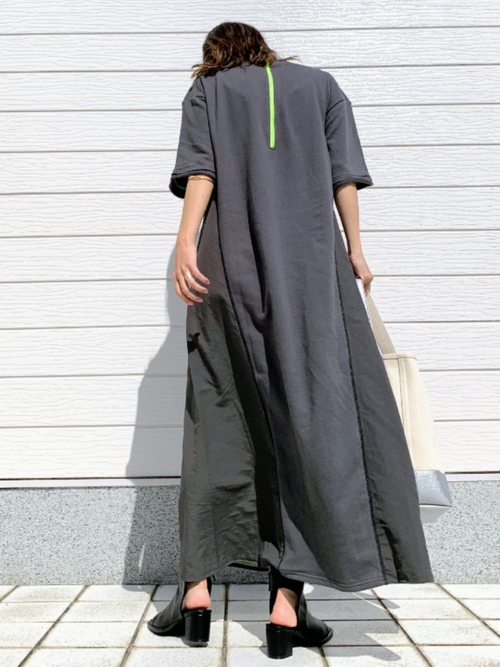ブラック系のサンダル、グレー系のワンピース、シルバー系のハンドバッグを着用したレディースの春コーディネートの3枚目の写真