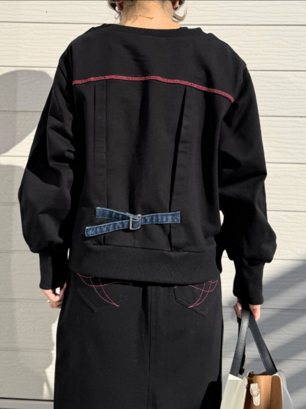ブルー系のスウェット、ブルー系のスカート、ホワイト系のトートバッグを着用したレディースの冬コーディネートの5枚目の写真