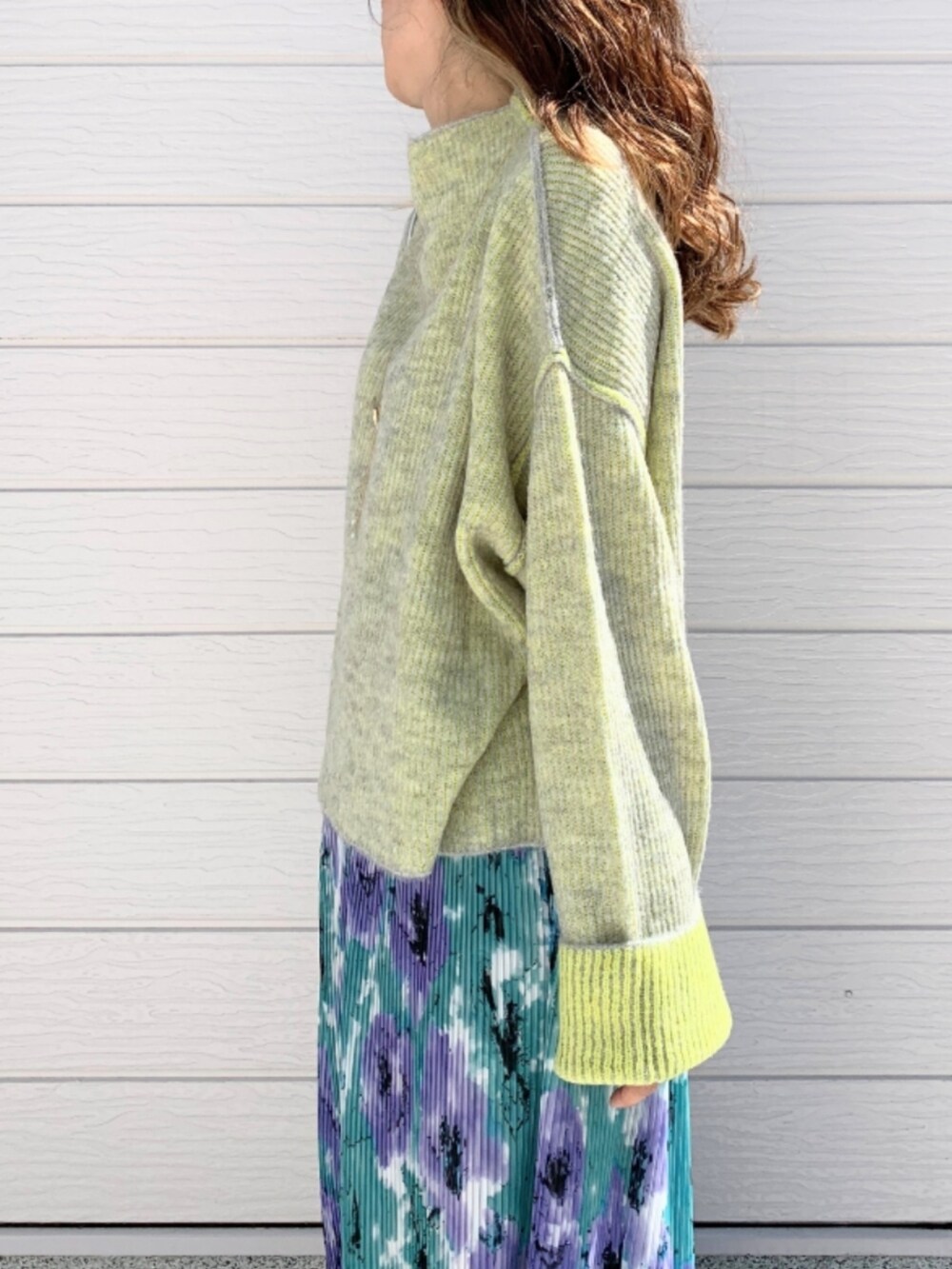 グリーン系のスカート、ホワイト系のスニーカー、シルバー系のショルダーバッグを着用したレディースの秋コーディネートの4枚目の写真