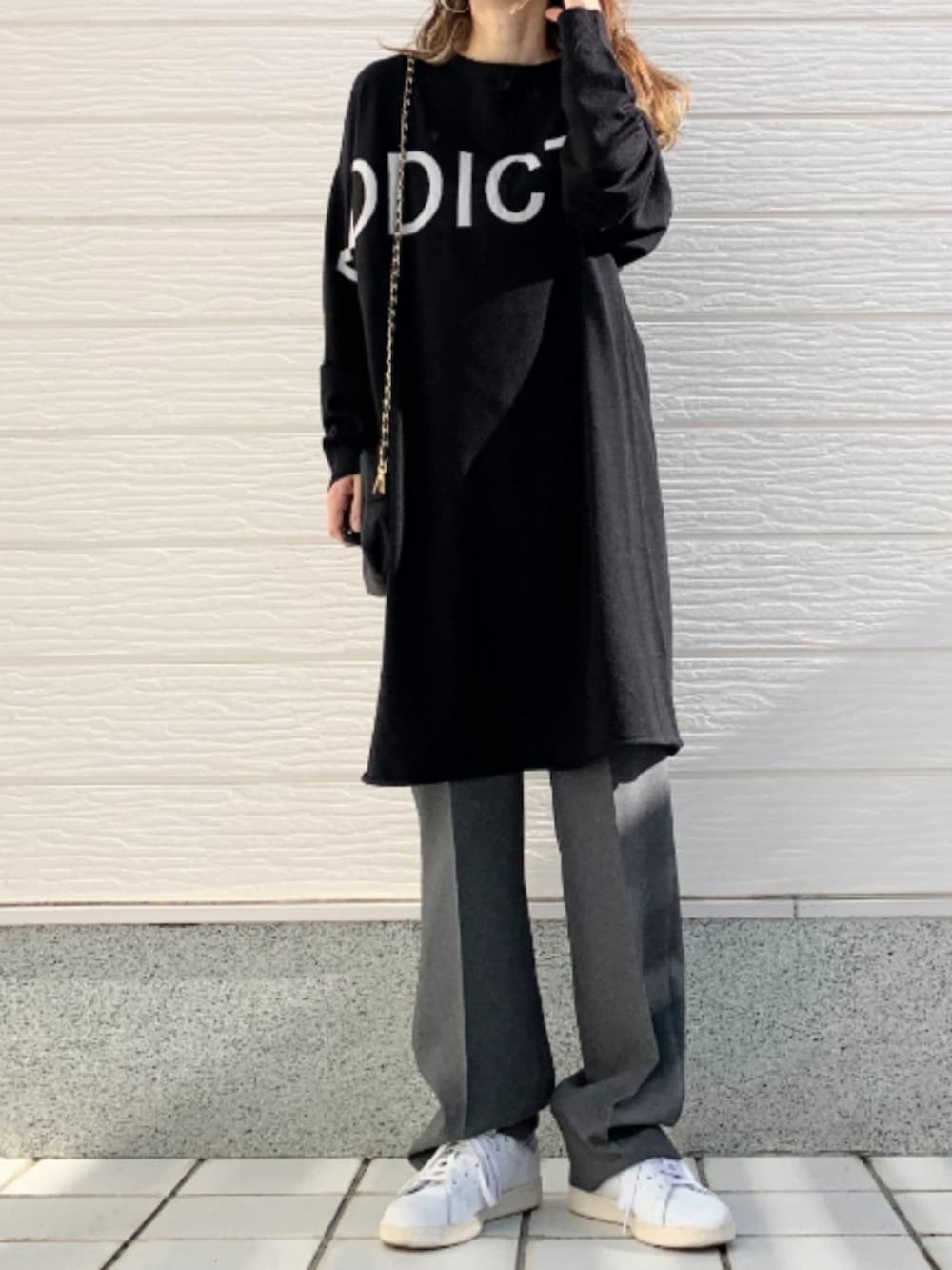 グレー系のその他パンツ、ホワイト系のスニーカー、ブラック系のニット/セーターを着用したレディースの冬コーディネートの2枚目の写真