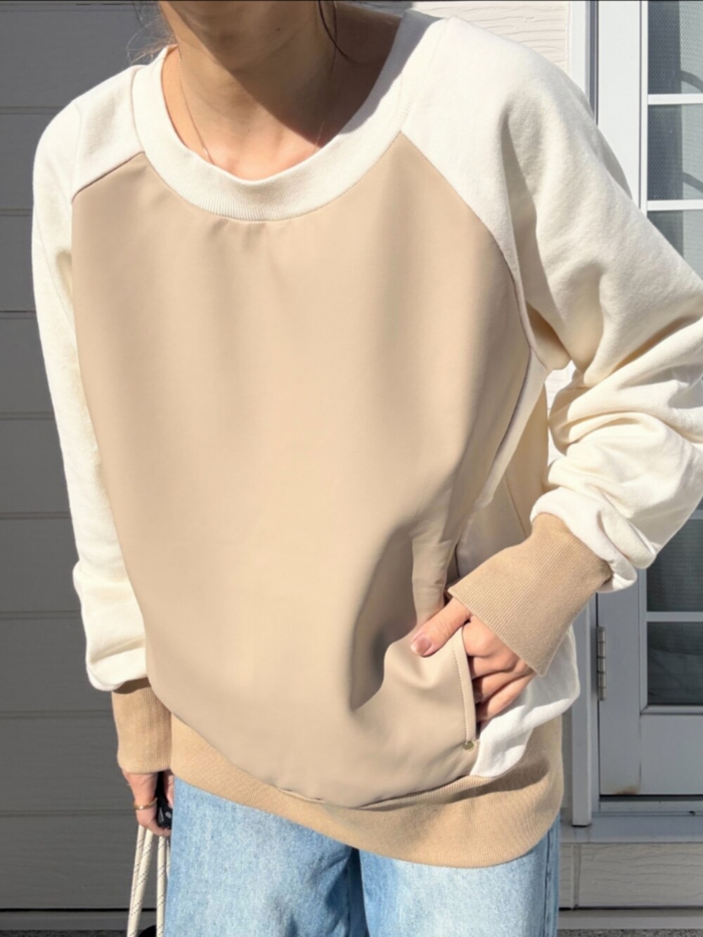 ブルー系のトートバッグ、ブルー系のデニムパンツ、ベージュ系のスウェットを着用したレディースの冬コーディネートの4枚目の写真