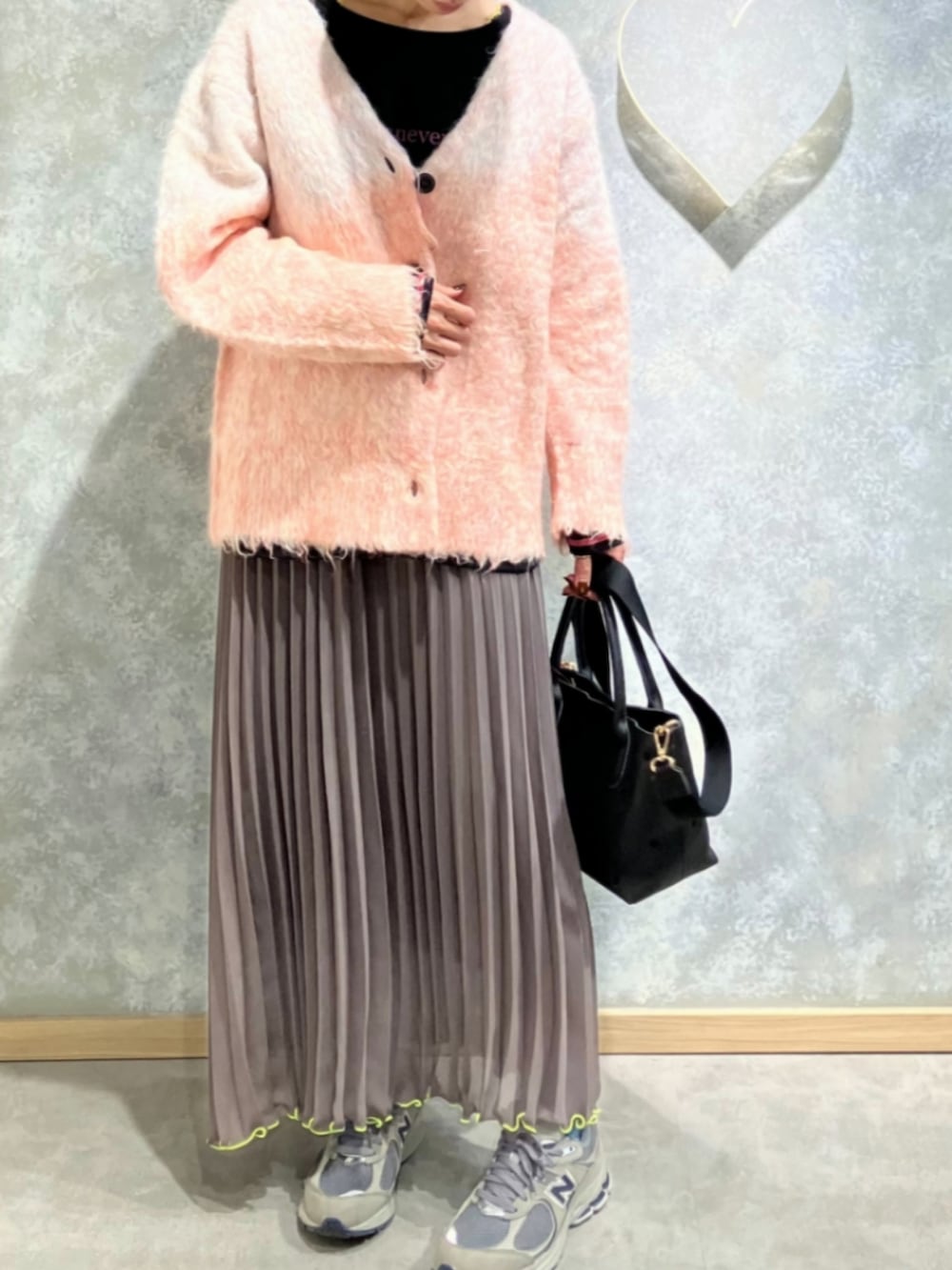 グリーン系のスカート、ブラック系のトートバッグ、ブラック系のTシャツ/カットソーを着用したレディースの冬コーディネートの2枚目の写真