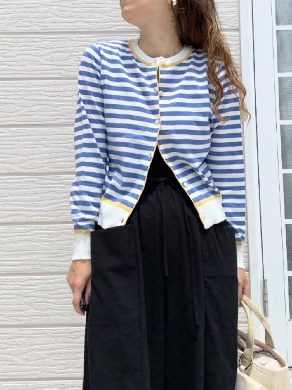 ベージュ系のトートバッグ、ブラック系のその他パンツ、ブルー系のカーディガン/ボレロを着用したレディースの夏コーディネートの4枚目の写真