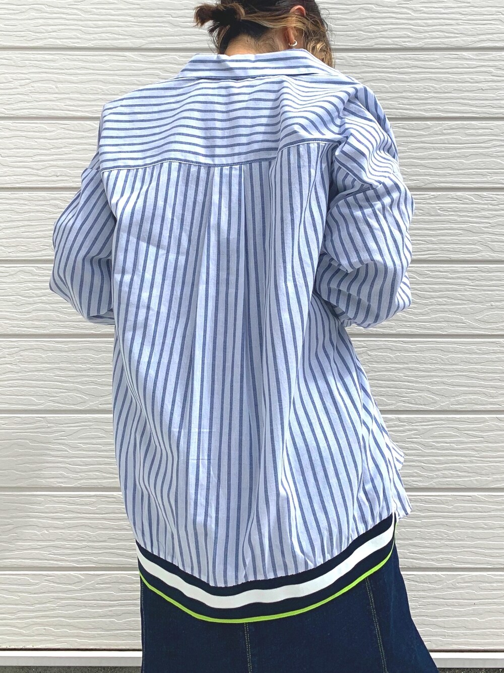 ブルー系のデニムスカート、グレー系のTシャツ/カットソー、ブラウン系のベストを着用したレディースの秋コーディネートの4枚目の写真