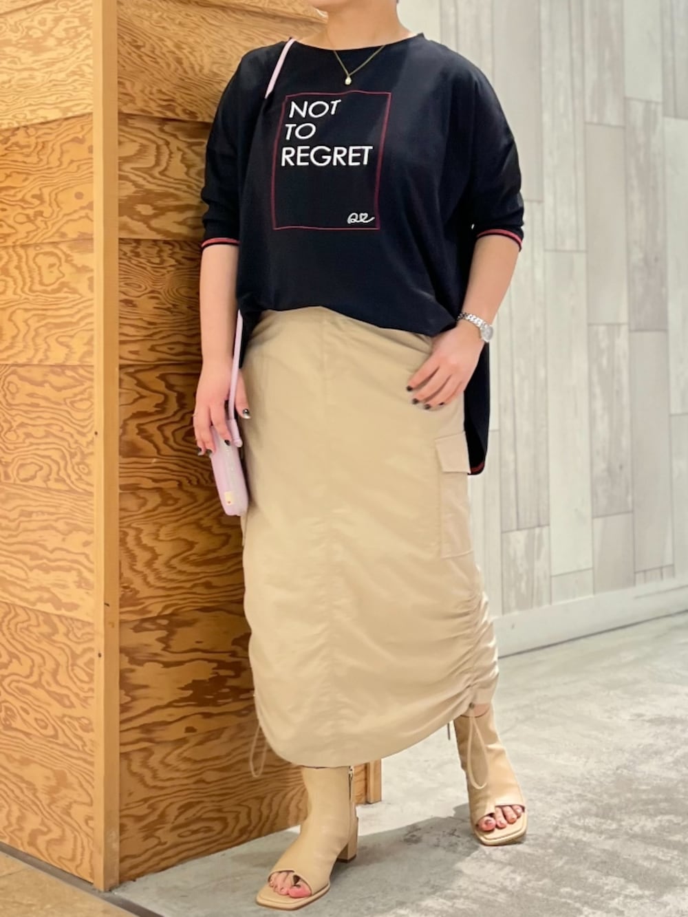 ベージュ系のサンダル、ブラック系のTシャツ/カットソー、ベージュ系のスカートを着用したレディースの春コーディネートの2枚目の写真