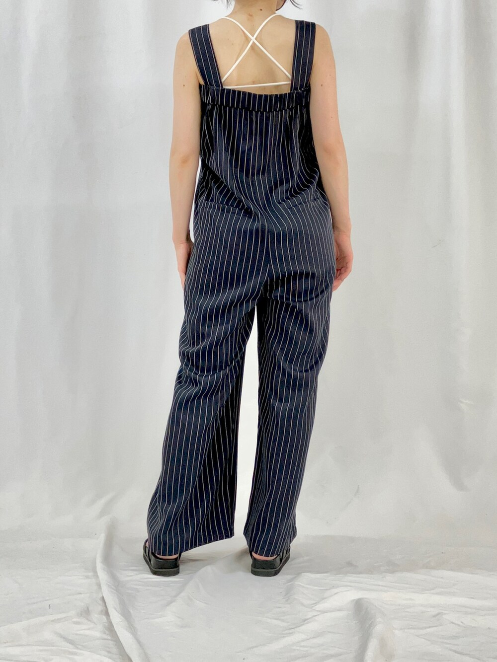 ベージュ系のブルゾン、ブルー系のサロペット/オーバーオール、ブラック系のサンダルを着用したレディースの春コーディネートの5枚目の写真