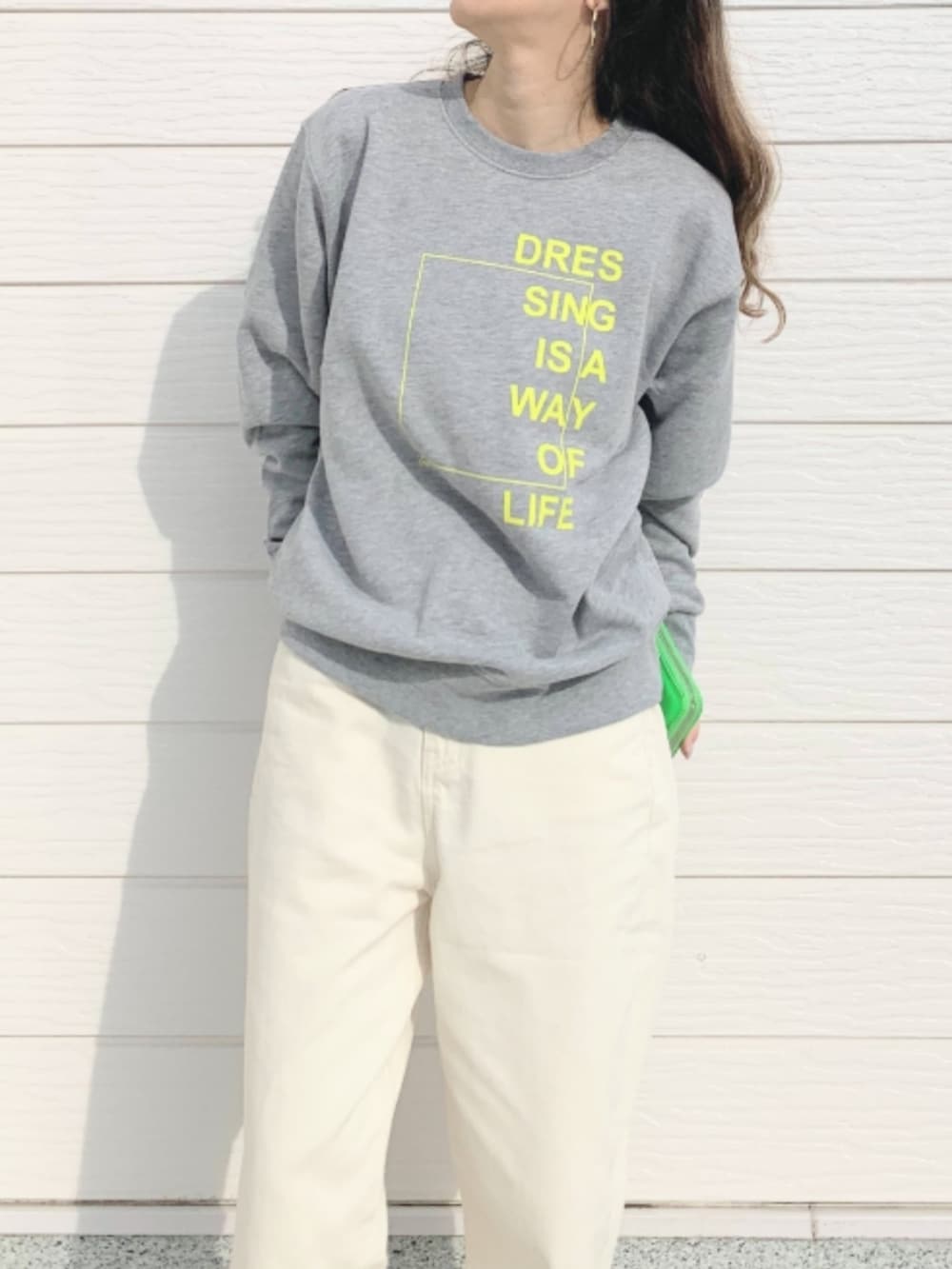 ホワイト系のデニムパンツ、グレー系のスウェット、グリーン系のコインケースを着用したレディースの冬コーディネートの3枚目の写真