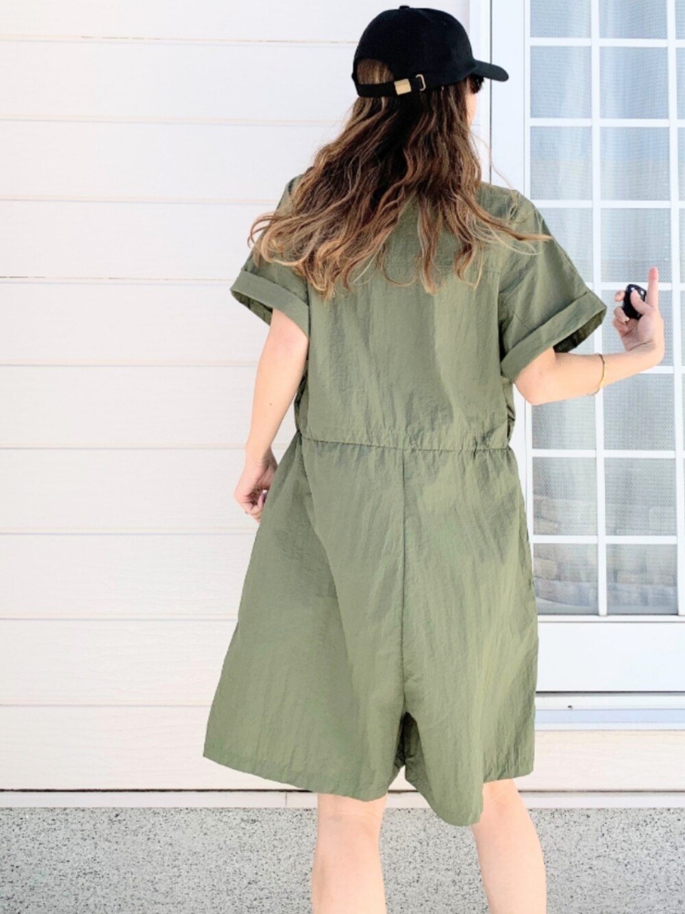 ホワイト系のスニーカー、グリーン系のつなぎ/オールインワン、ブラック系のキャップを着用したレディースの春コーディネートの4枚目の写真