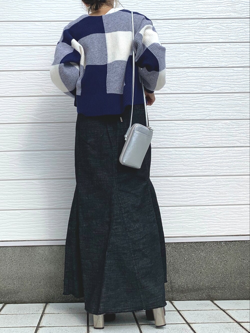 ホワイト系のTシャツ/カットソー、ブラック系のデニムスカート、ブラウン系のブーツを着用したレディースの秋コーディネートの2枚目の写真