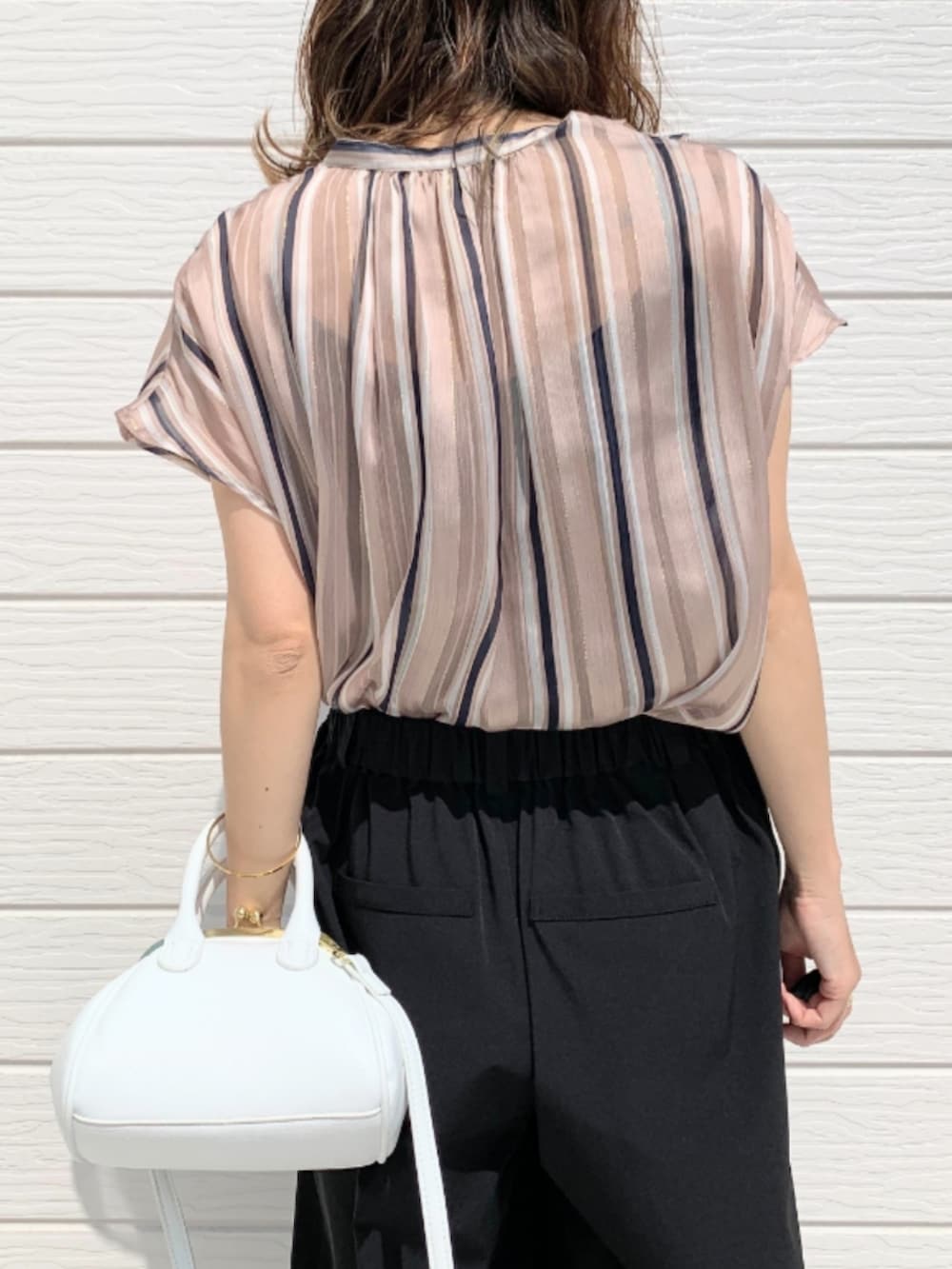 ホワイト系のショルダーバッグ、ブラック系のその他パンツ、ブラウン系のサンダルを着用したレディースの春コーディネートの5枚目の写真