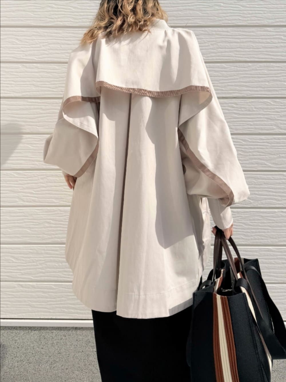 ブラック系のトートバッグ、ブラック系のサンダル、ブラック系のスカートを着用したレディースの冬コーディネートの5枚目の写真