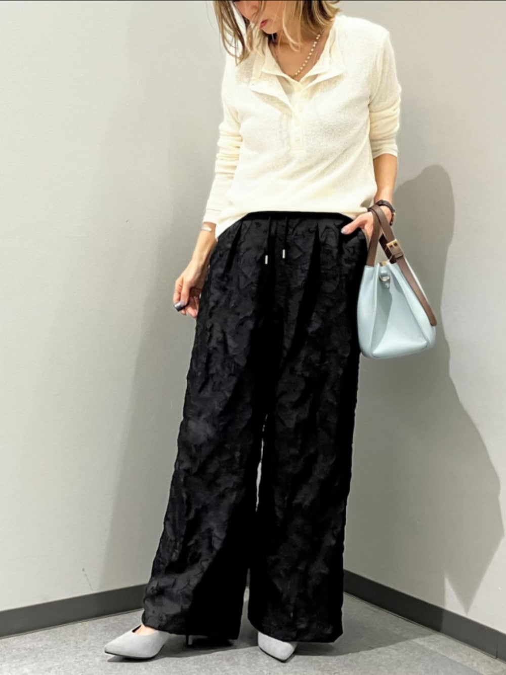 ブルー系のトートバッグ、ブラック系のその他パンツ、ホワイト系のTシャツ/カットソーを着用したレディースの春コーディネートの3枚目の写真