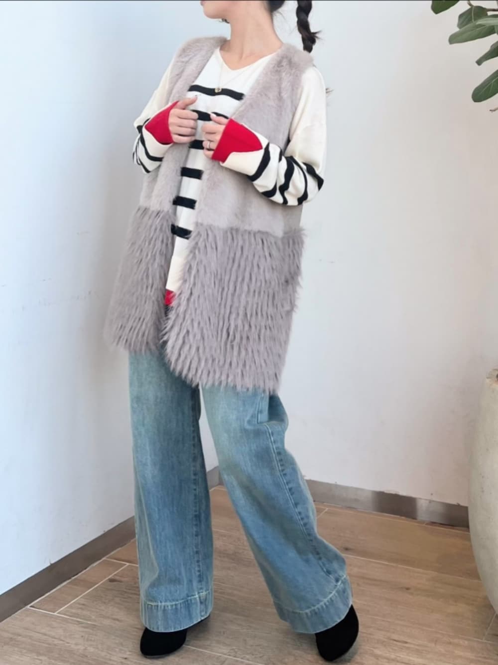 ブルー系のデニムパンツ、ホワイト系のニット/セーター、グレー系のベストを着用したレディースの冬コーディネートの2枚目の写真