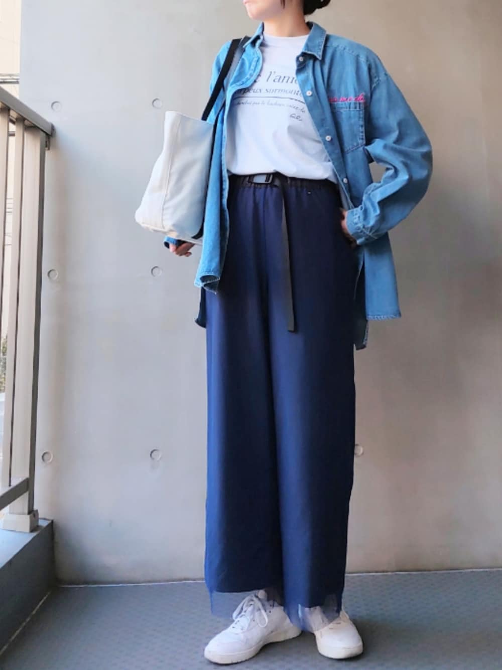 ホワイト系のトートバッグ、ホワイト系のスニーカー、ブルー系のシャツ/ブラウスを着用したレディースの冬コーディネートの2枚目の写真