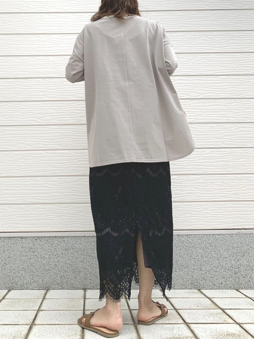 オレンジ系のハンドバッグ、ベージュ系のTシャツ/カットソー、ブラック系のスカートを着用したレディースの春コーディネートの3枚目の写真