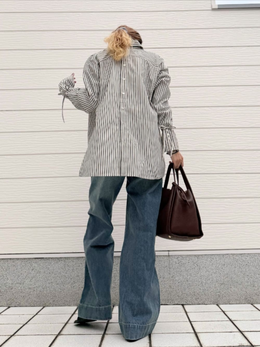 ブラウン系のハンドバッグ、ブラック系のシャツ/ブラウス、グレー系のTシャツ/カットソーを着用したレディースの秋コーディネートの3枚目の写真