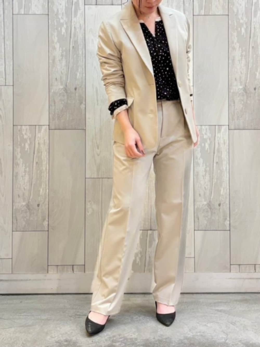 ベージュ系のスラックス、ベージュ系のテーラードジャケット、ブラック系のシャツ/ブラウスを着用したレディースの春コーディネートの2枚目の写真