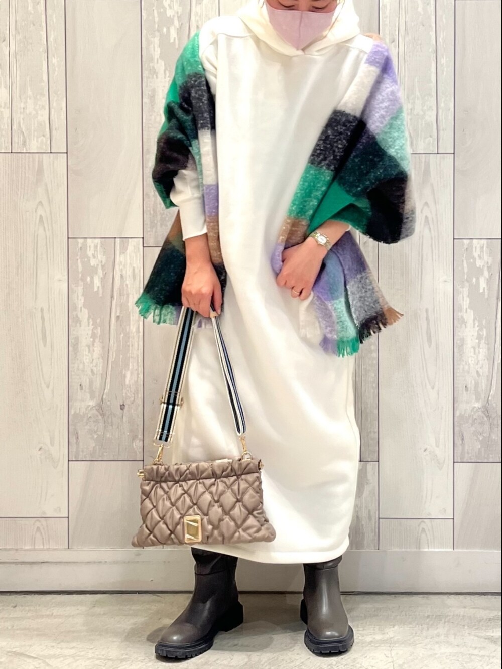 ベージュ系のショルダーバッグ、ホワイト系のワンピース、グレー系のブーツを着用したレディースの冬コーディネートの2枚目の写真