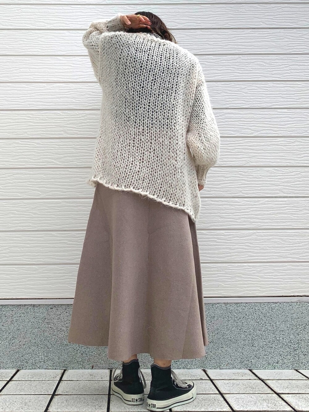 ホワイト系のニット/セーター、ブラック系のTシャツ/カットソー、ブラック系のスニーカーを着用したレディースの冬コーディネートの3枚目の写真