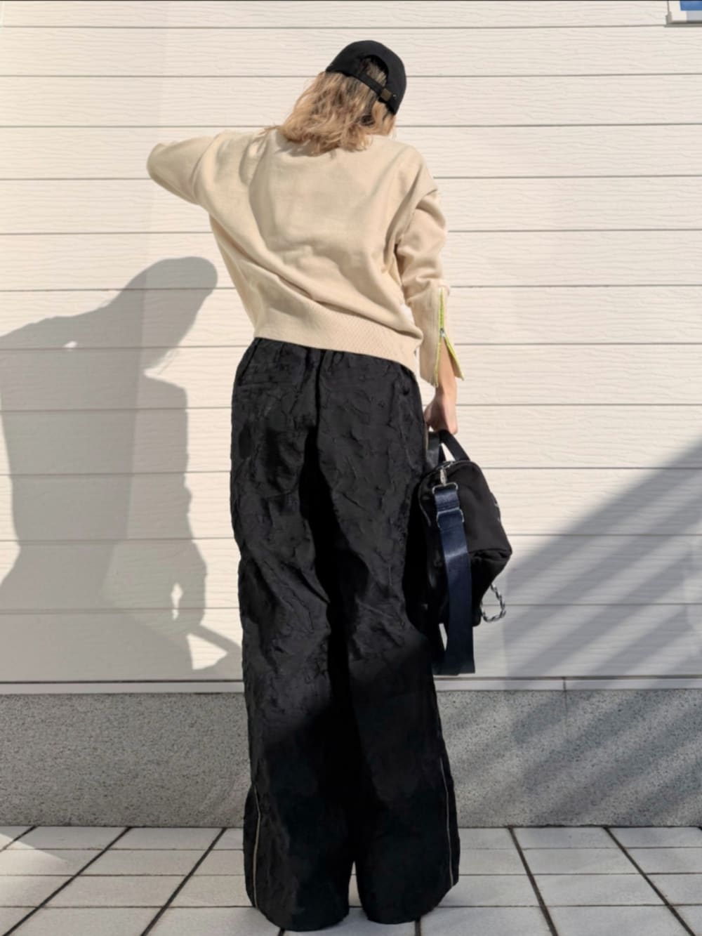 ホワイト系のニット/セーター、ブラック系のボストンバッグ、ブラック系のその他パンツを着用したレディースの冬コーディネートの3枚目の写真