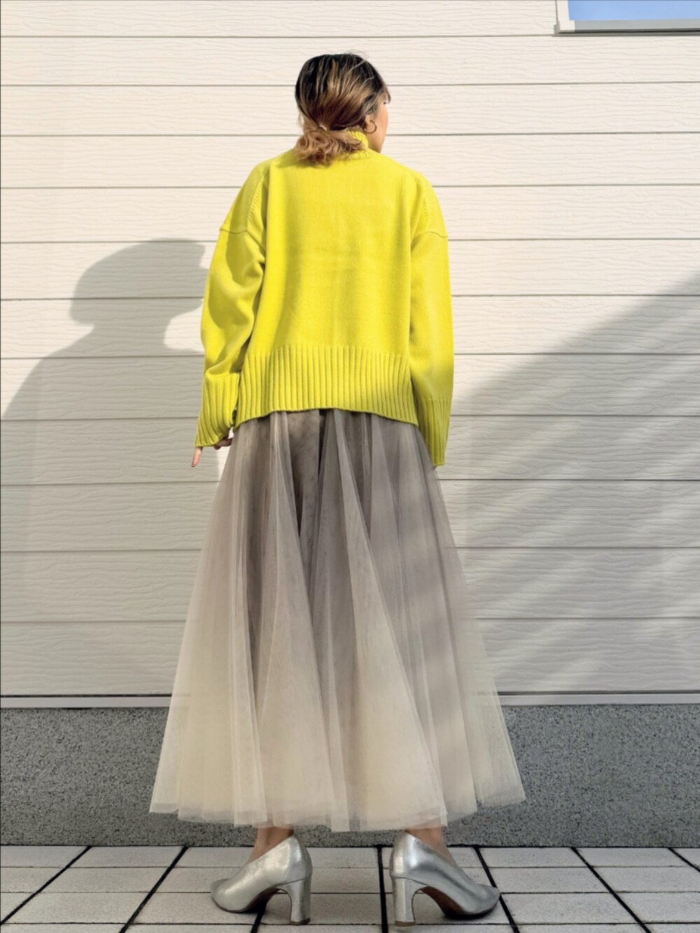 ゴールド系のスカート、グリーン系のニット/セーターを着用したレディースの冬コーディネートの3枚目の写真
