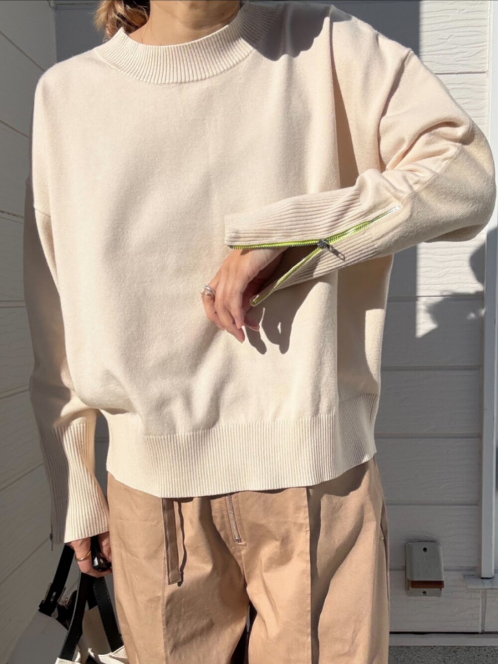ホワイト系のスニーカー、ホワイト系のニット/セーター、ベージュ系のその他パンツを着用したレディースの冬コーディネートの5枚目の写真