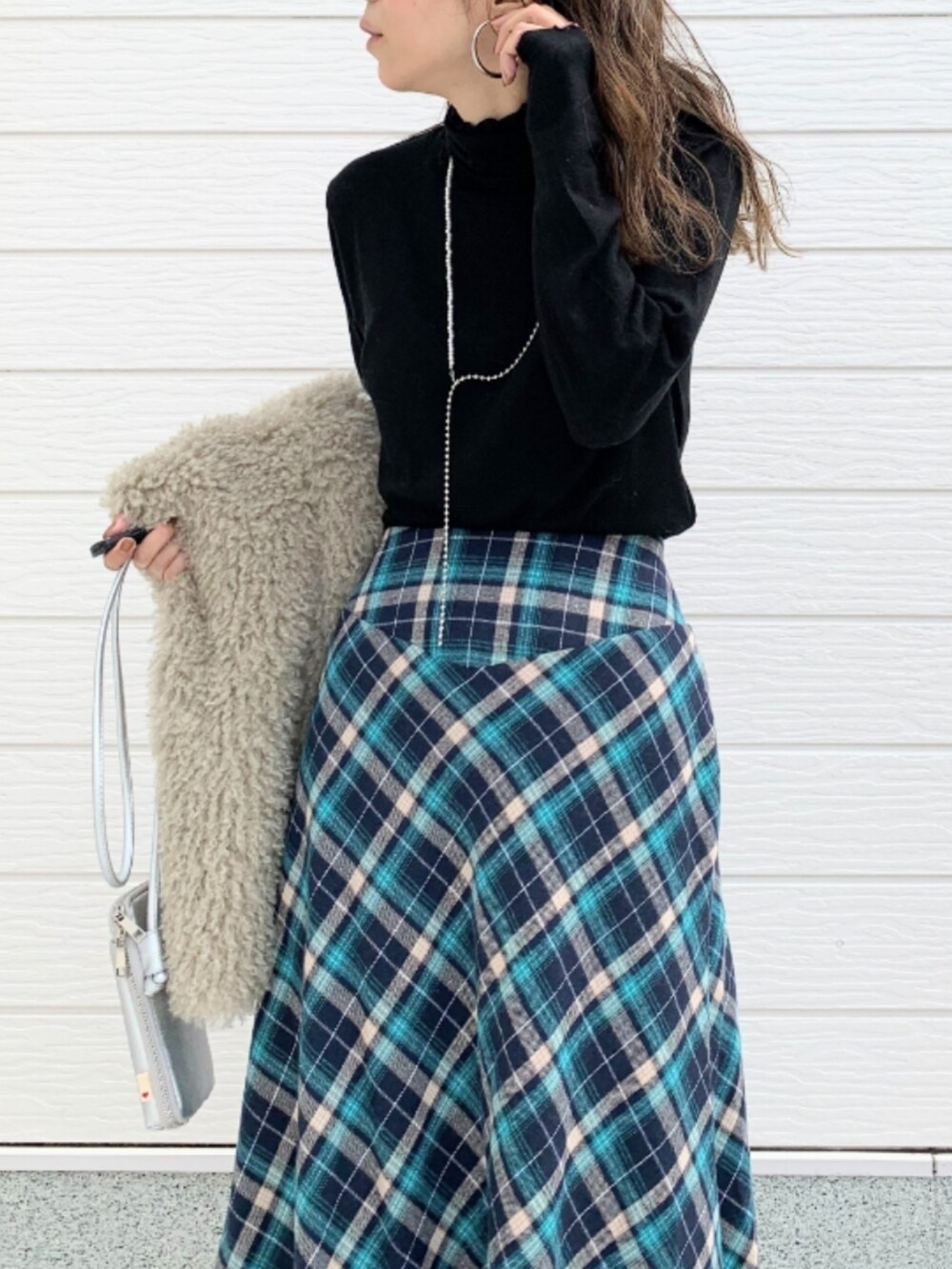 ベージュ系のベスト、シルバー系のショルダーバッグ、ブルー系のスカートを着用したレディースの秋コーディネートの5枚目の写真