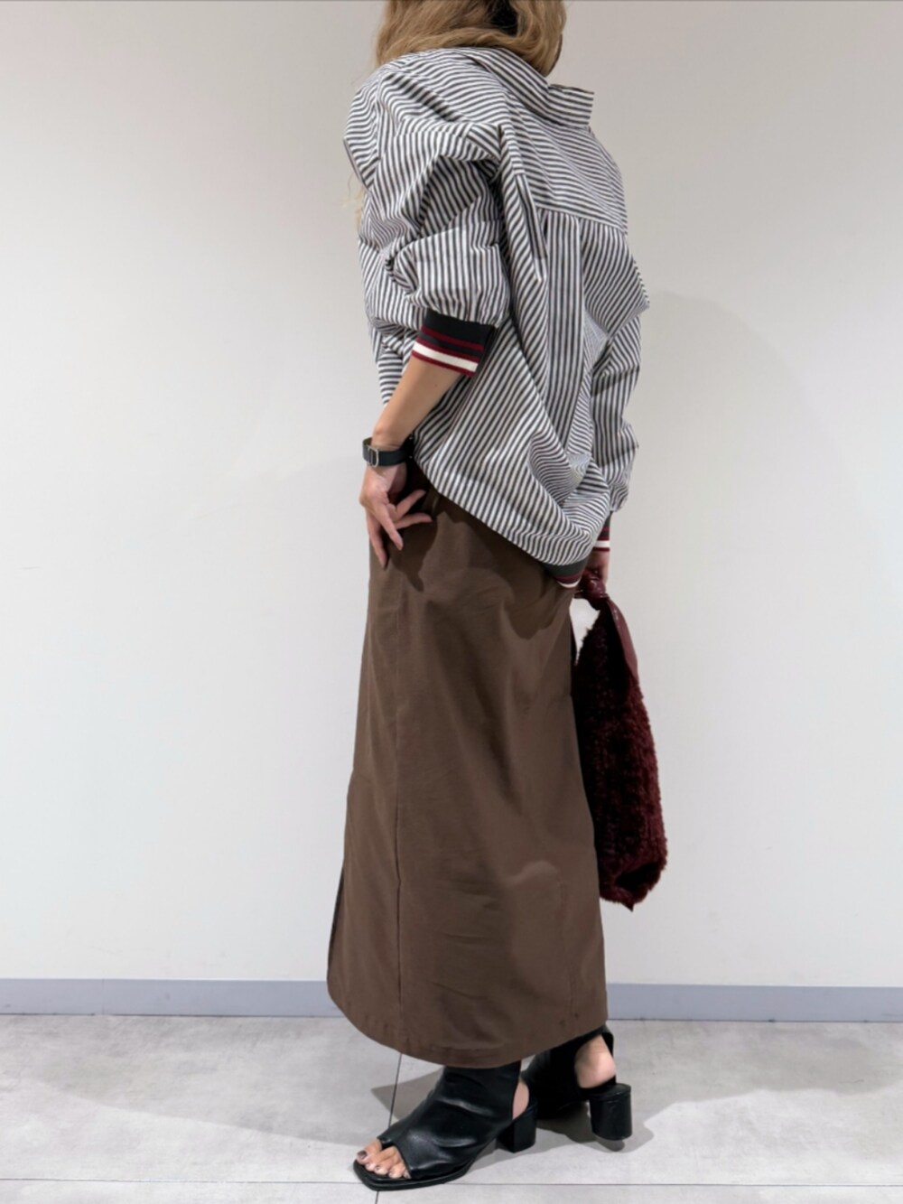 ブラック系のサンダル、ブラウン系のスカート、ブラック系のシャツ/ブラウスを着用したレディースの秋コーディネートの2枚目の写真