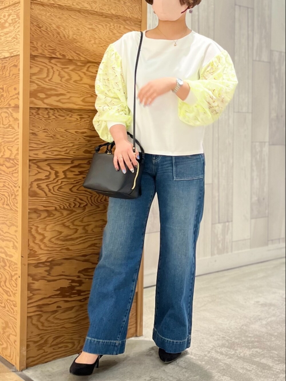 ブルー系のデニムパンツ、ホワイト系のTシャツ/カットソー、ブラック系のハンドバッグを着用したレディースの春コーディネートの2枚目の写真