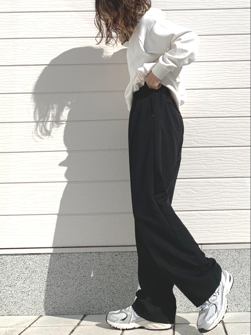 ブラック系のその他パンツ、シルバー系のスニーカー、ホワイト系のパーカーを着用したレディースの冬コーディネートの2枚目の写真