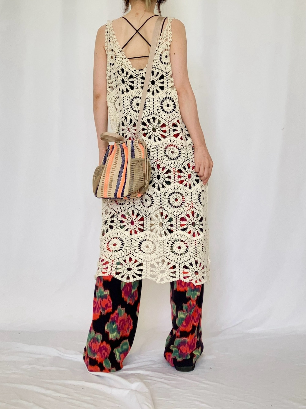 ベージュ系のトートバッグ、ホワイト系のワンピース、ブラック系のキャミソールを着用したレディースの夏コーディネートの3枚目の写真