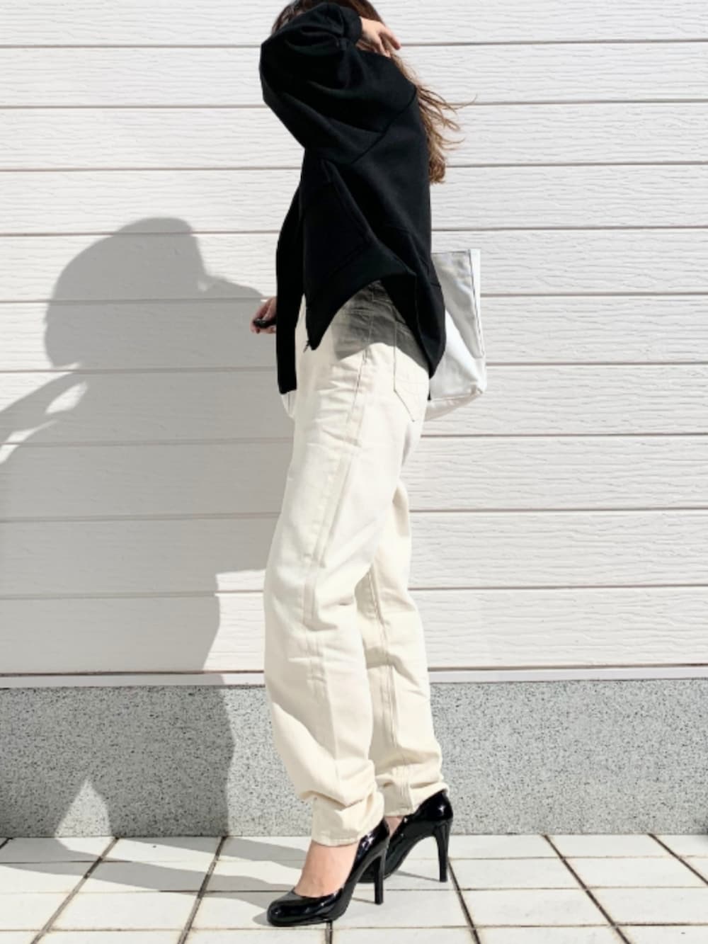 ホワイト系のトートバッグ、ホワイト系のTシャツ/カットソー、ホワイト系のデニムパンツを着用したレディースの冬コーディネートの3枚目の写真