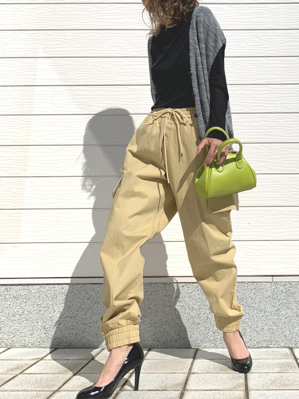 ベージュ系のその他パンツ、グリーン系のショルダーバッグ、ブラック系のTシャツ/カットソーを着用したレディースの春コーディネートの2枚目の写真