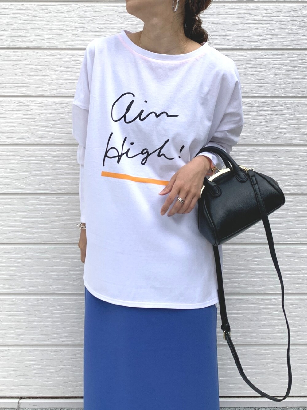 ブラック系のサンダル、ブラック系のショルダーバッグ、ブルー系のスカートを着用したレディースの春コーディネートの4枚目の写真