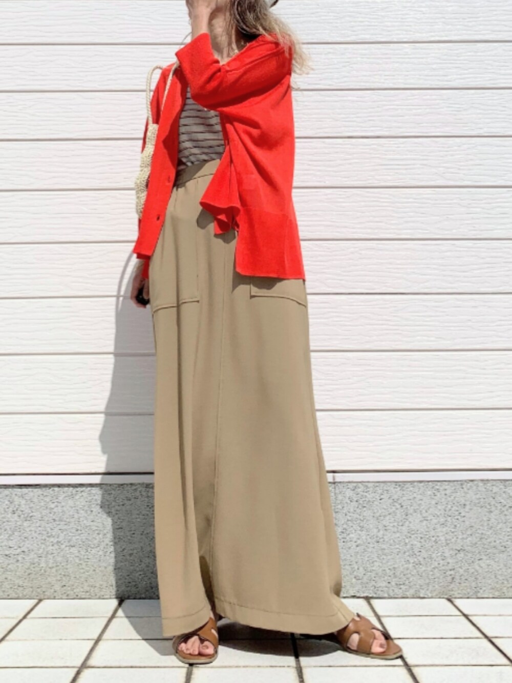 イエロー系のサンダル、オレンジ系のカーディガン/ボレロ、ホワイト系のトートバッグを着用したレディースの春コーディネートの3枚目の写真