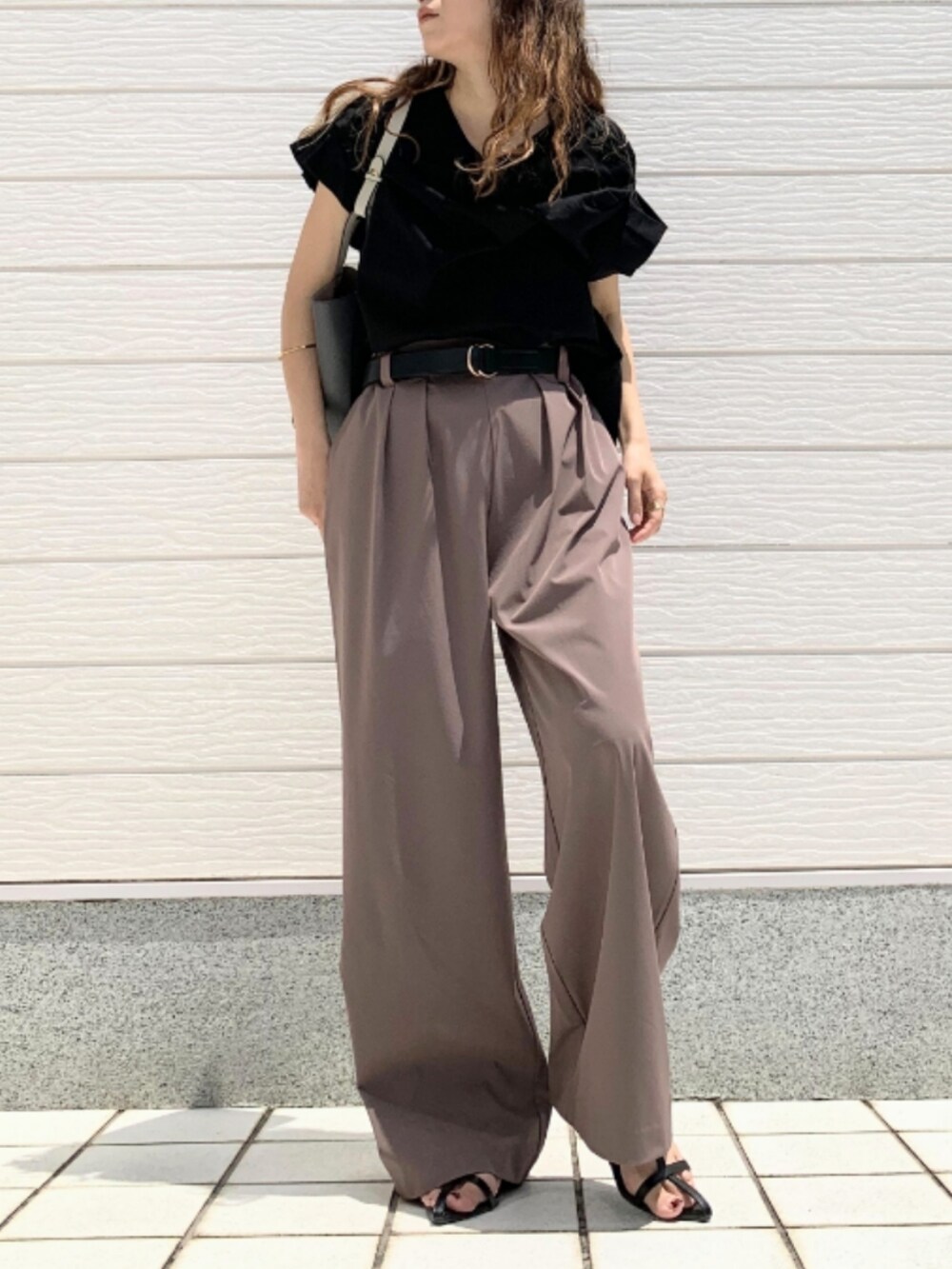 ブラウン系のその他パンツ、グレー系のトートバッグ、ブラック系のTシャツ/カットソーを着用したレディースの春コーディネートの2枚目の写真