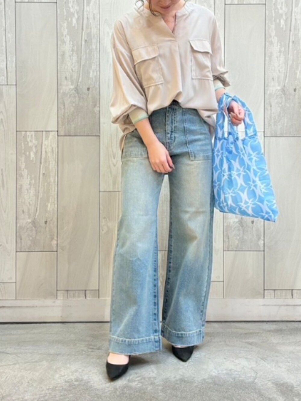 ブルー系のデニムパンツ、ブルー系のエコバッグ/サブバッグ、ベージュ系のシャツ/ブラウスを着用したレディースの冬コーディネートの2枚目の写真
