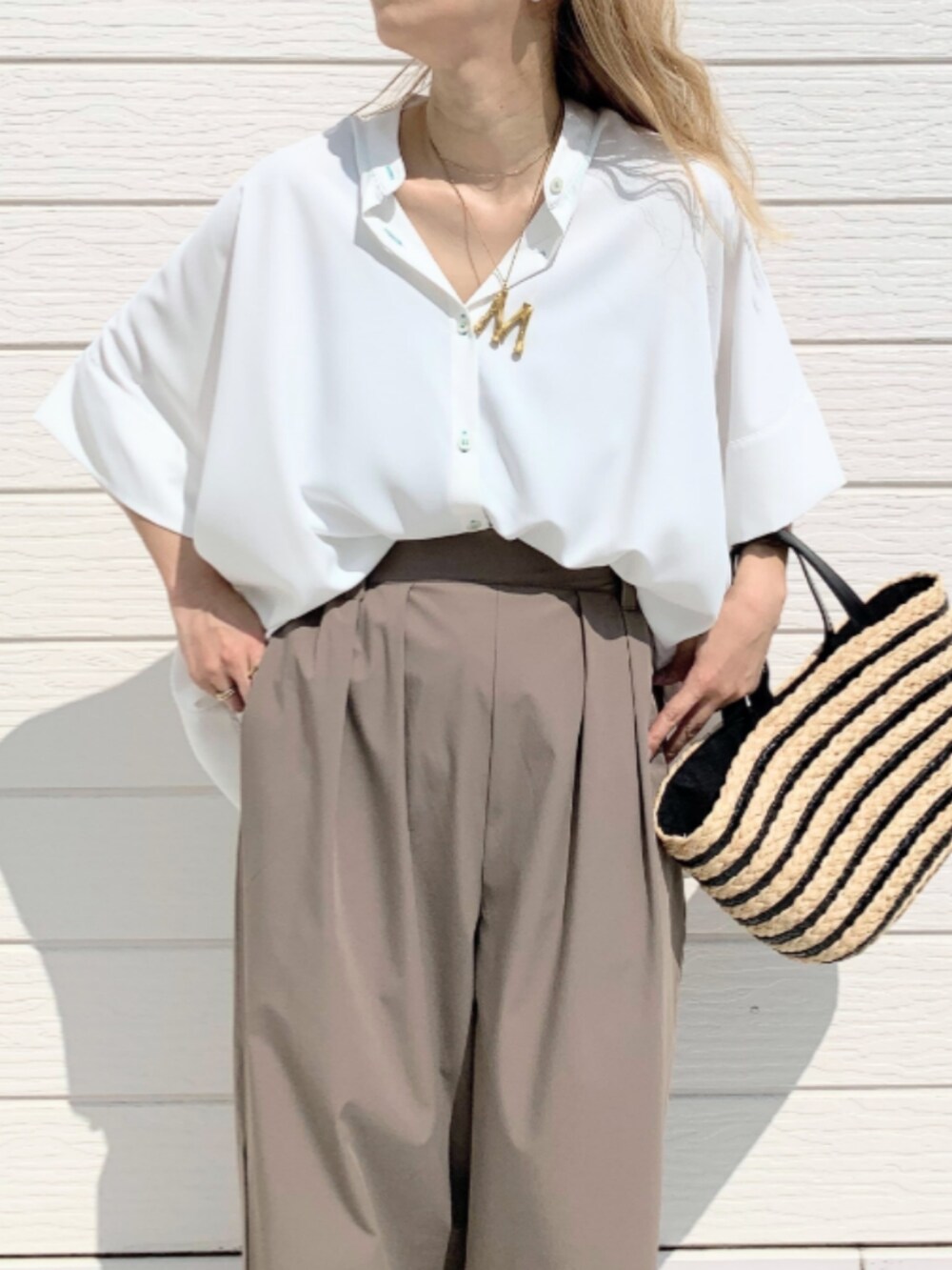 ブラック系のかごバッグ、グレー系のその他パンツ、ホワイト系のシャツ/ブラウスを着用したレディースの春コーディネートの3枚目の写真