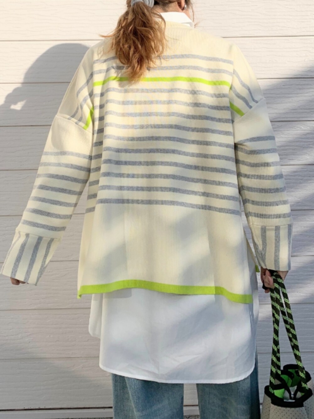 ブルー系のデニムパンツ、ホワイト系のシャツ/ブラウス、グレー系のトートバッグを着用したレディースの冬コーディネートの3枚目の写真