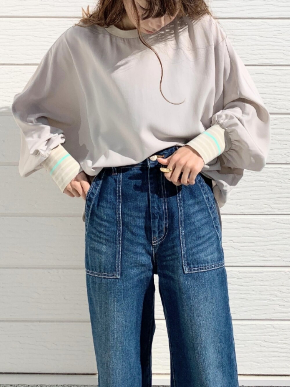 ブルー系のデニムパンツ、ホワイト系のスニーカー、ベージュ系のシャツ/ブラウスを着用したレディースの冬コーディネートの4枚目の写真