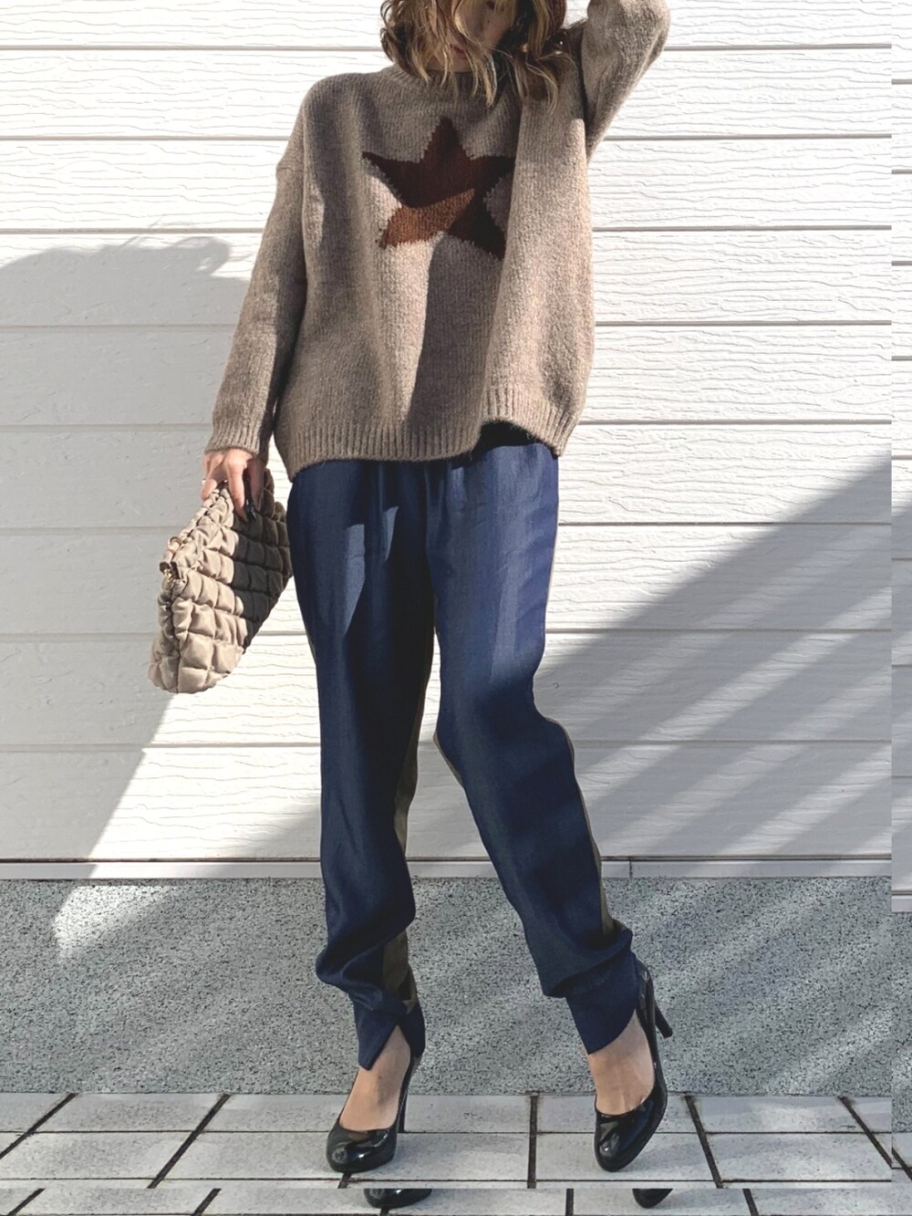 グリーン系のデニムパンツ、グレー系のニット/セーター、ベージュ系のショルダーバッグを着用したレディースの冬コーディネートの3枚目の写真