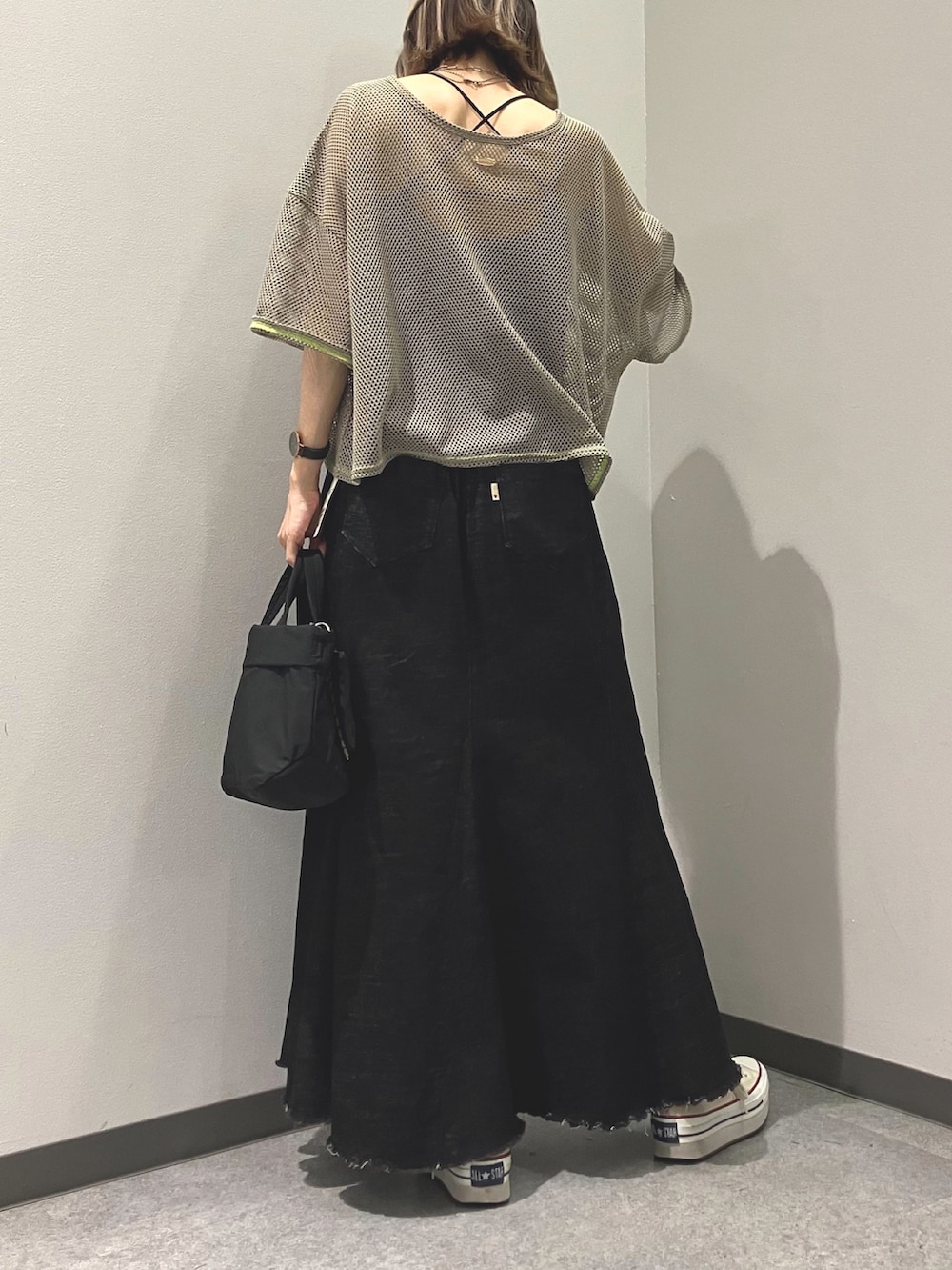 グリーン系のTシャツ/カットソー、ブラック系のデニムスカート、ブラック系のショルダーバッグを着用したレディースの夏コーディネートの2枚目の写真
