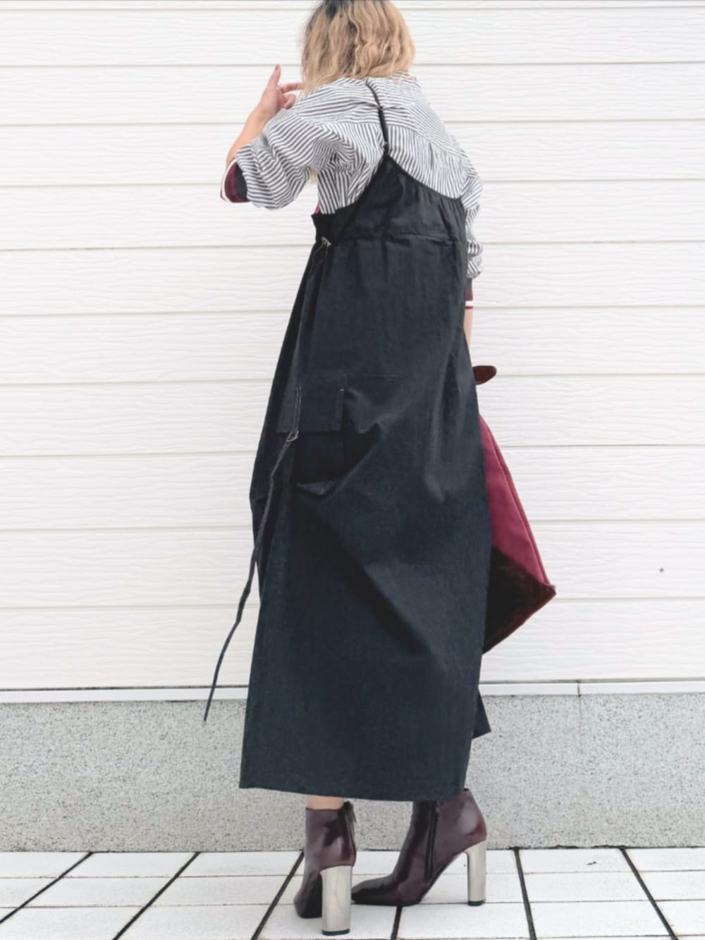 ブラウン系のブーツ、ブラック系のジャンパースカート、ブラック系のシャツ/ブラウスを着用したレディースの秋コーディネートの4枚目の写真