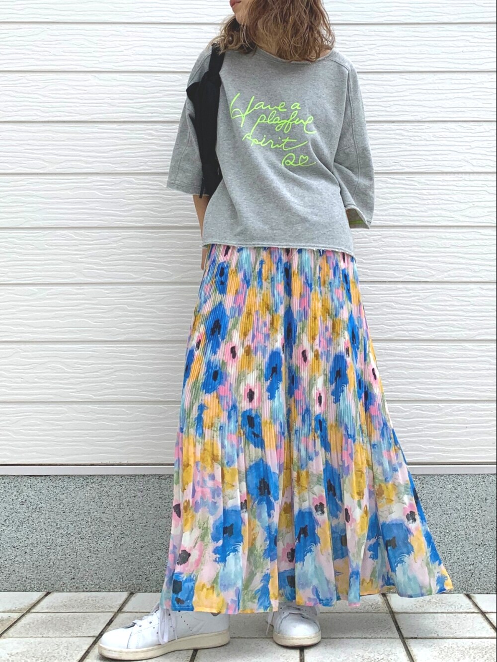 ホワイト系のスニーカー、ブラック系のショルダーバッグ、ブルー系のスカートを着用したレディースの春コーディネートの2枚目の写真