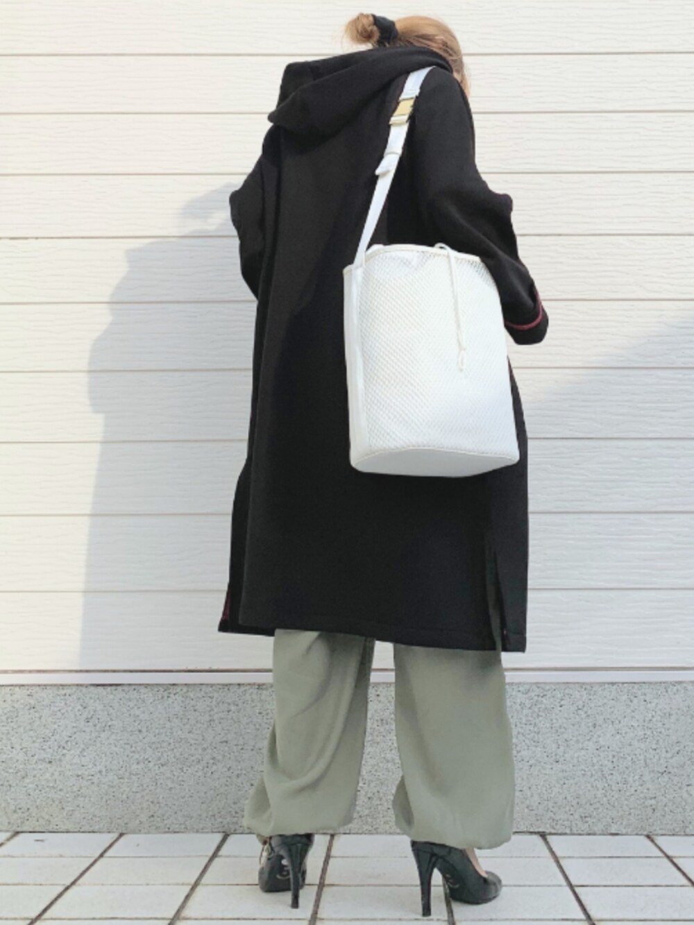 ブラック系のその他アウター、ホワイト系のショルダーバッグ、ブラック系のニット/セーターを着用したレディースの冬コーディネートの3枚目の写真