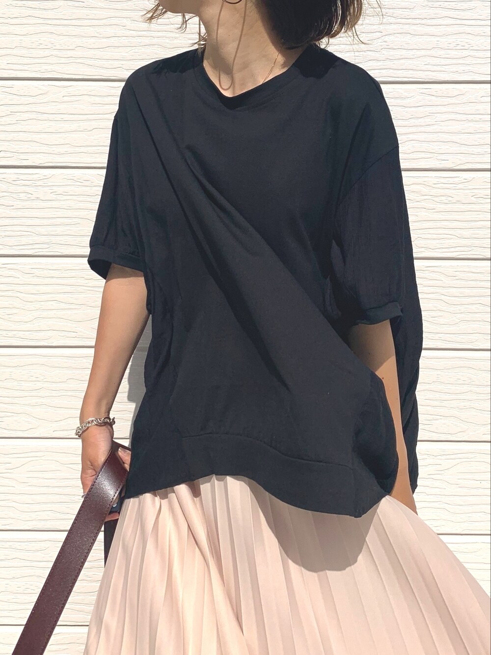 ベージュ系のスカート、ブラウン系のショルダーバッグ、ベージュ系のサンダルを着用したレディースの夏コーディネートの2枚目の写真