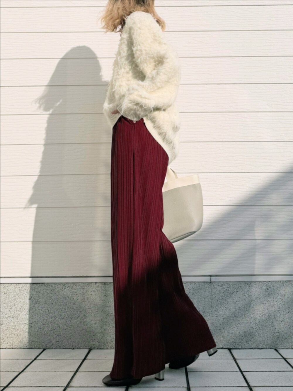 ホワイト系のニット/セーター、レッド系のその他パンツ、グレー系のトートバッグを着用したレディースの秋コーディネートの2枚目の写真