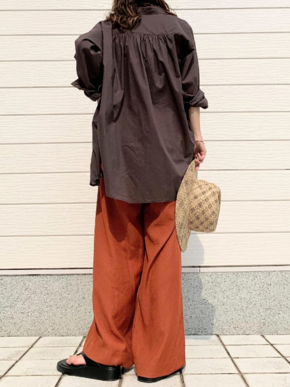 ブラウン系のその他パンツ、ブラック系のキャミソール、グレー系のシャツ/ブラウスを着用したレディースの夏コーディネートの2枚目の写真